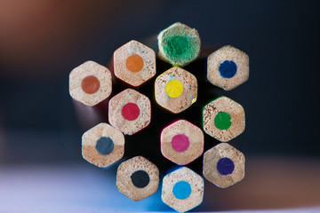Pile of sharp coloured drawing pencils on table. Rainbow colors  red, yellow, blue, green, purple. Concept of art, crafts and kids having fun
