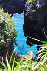 Looking through the rocky hill to see the clear blue sea below