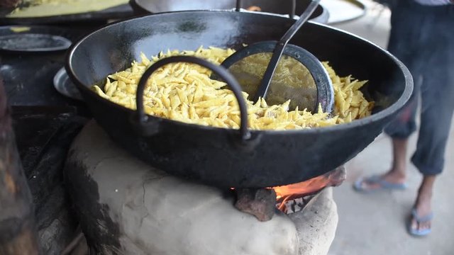 Indian Street snacks for fairs is being fried on a Wok on fire on streets in India, Kolkata