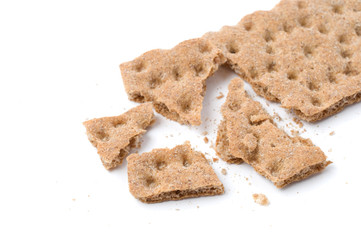 Crunchy crispbread with crumbs on white background.