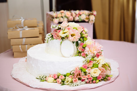 Close-up photo of a wedding cake decorated with fresh flowers, a wedding table, dessert, ideas for celebrating a wedding, a kitchen.