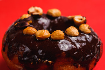 Chocolate donut with hazelnutred on a red background