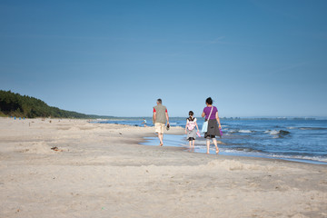 Rodzinny spacer po plaży - obrazy, fototapety, plakaty