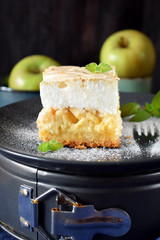 Piece of meringue pie with fruits and cottage cheese on a dark plate