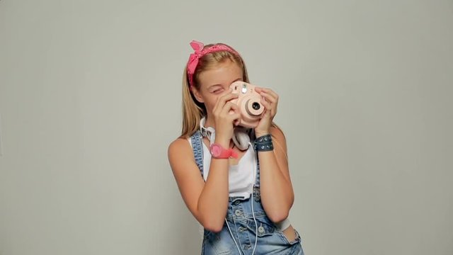 Young hipster girl holding retor insta polaroid camera taking photo portrait.
