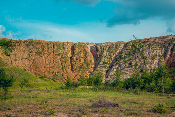 Weathered quarry cliff with grassy bottom