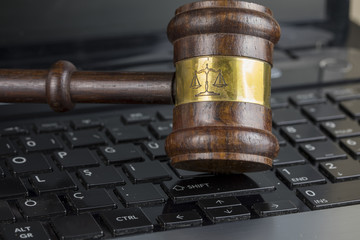 Wooden Judge Hammer on Laptop Computer White Keyboard