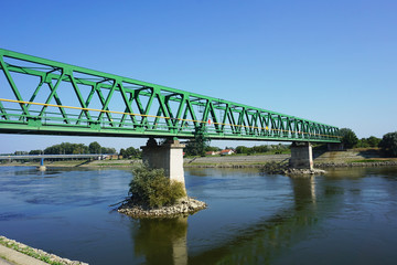 Waterfront view of rail bridge across river Drava in Croatian town Osijek in a summer sunny day