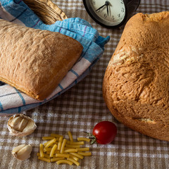 Naklejka premium Bread on tablecloth tomato and hour
