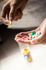 Colorful capsules tablets hold on hand. Image use for health care concept