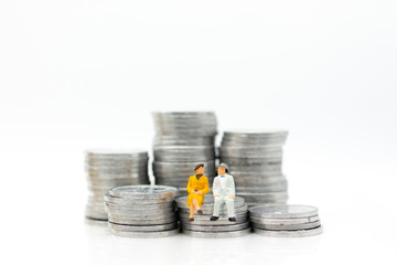 Miniature people, adult couple figure standing on top of stack coins . Image use for background retirement planning, Life insurance concept.