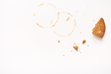 Cookie crumbs and coffee stains on white table.