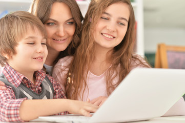 Fototapeta na wymiar Portrait of a happy family using laptop