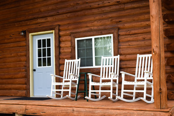 Obraz na płótnie Canvas Rocking chairs on log cabin porch