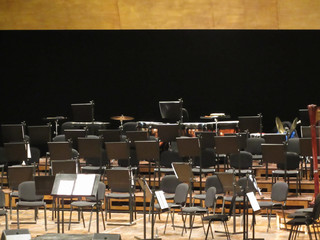 Empty chairs stand on stage in concert hall