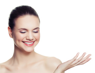 Young healthy woman spa model smiling and showing empty copy space on the open hand isolated on white
