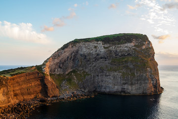 Mountain peninsula in Faial Island near the sea during a sunset with some clouds