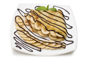 Crepes with chocolate cream and banana on white background.