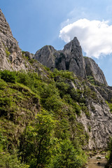 High mountain cliff edge against blue sky with clouds