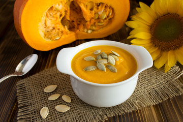 Soup with pumpkin  in the white plate on the rustic wooden  background