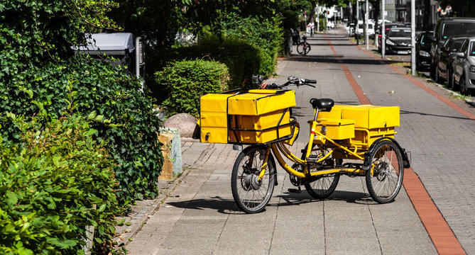 Postfahrrad Brieftr&auml;ger bei der Zustellung