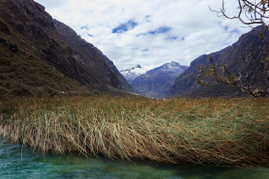 LLANGANUCO LAKE TURQUOISE COLOR WITH ICHU AND HUASCARAN PEAK IN HUARAZ, PERU.