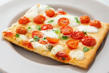 Fetta di pizza con pomodoro, mozzarella e basilico 