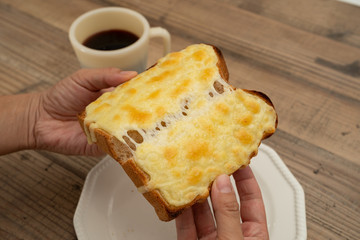 チーズたっぷりのトーストをちぎる