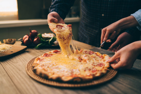 Slice Of Hot Pepperoni Pizza, Large Cheese Lunch Or Dinner With Cheese. Delicious Tasty Fast Food Italian Traditional On Wooden Board Table Classic In Side View. People Hands Taking Slices Of Pizza.