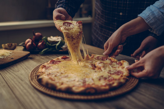 Slice Of Hot Pepperoni Pizza, Large Cheese Lunch Or Dinner With Cheese. Delicious Tasty Fast Food Italian Traditional On Wooden Board Table Classic In Side View. People Hands Taking Slices Of Pizza.