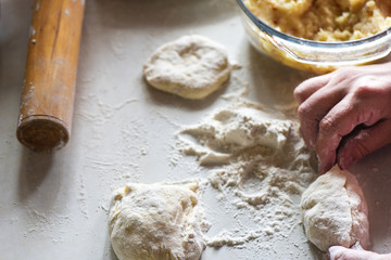 Formed raw potato pie in female hands