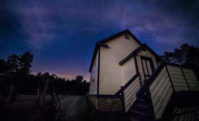 A country church beside a graveyard at night.