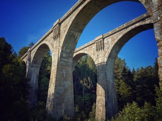 Historical railway bridges made in bricks in Stańczyki, clear blue sky and green valley