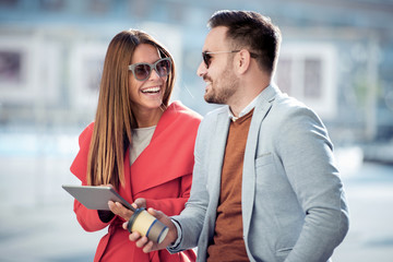 Lovely couple with tablet and coffee to go