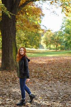 Young happy woman enjoying autumn day in park
