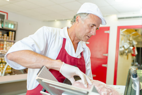 Man slicing meat with machine