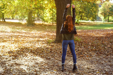 Ginger woman enjoying autumn day in park
