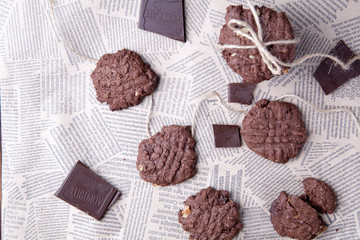  Chocolate chip chocolate cookies with chocolate pieces and milk on a vintage background. Moody rustic look.