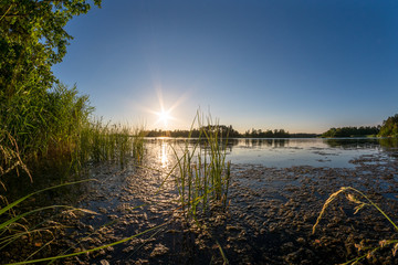 Beautiful view at a sunset behind blue water © DZiegler