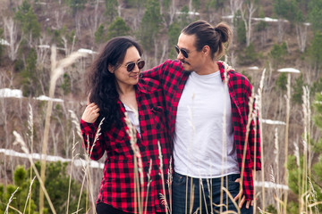 Mixed race asian couple in red flannel shirts hiking