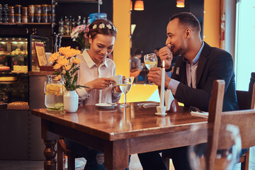 Happy attractive African-American couple in love having a great time together in a restaurant at their dating. A beautiful couple enjoying each other.