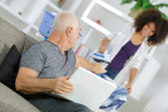 old man using laptop while talking to her assistant
