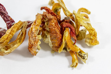 Close-up shot dried orange colored peppers on white background