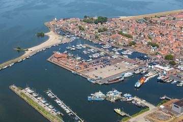 Aerial view Dutch fishing village with harbor, lighthouse and residential area - obrazy, fototapety, plakaty