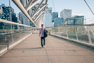 a tourist on the Akrobaten pedestrian bridge in Oslo, Norway