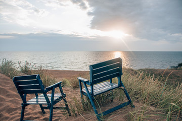 Fototapeta premium two seats watching the sunset above the sea