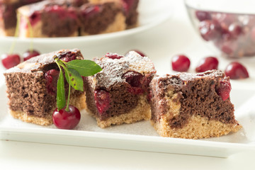 Sliced marble cake with sour cherry on white plate