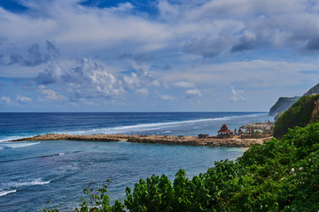 Tropical beach with rocky mountains and clear water of Indian ocean. View of turquoise bay with rocks and fluffy sky cloud. Clear water of the lagoon. Turquoise water background. Travel concept.