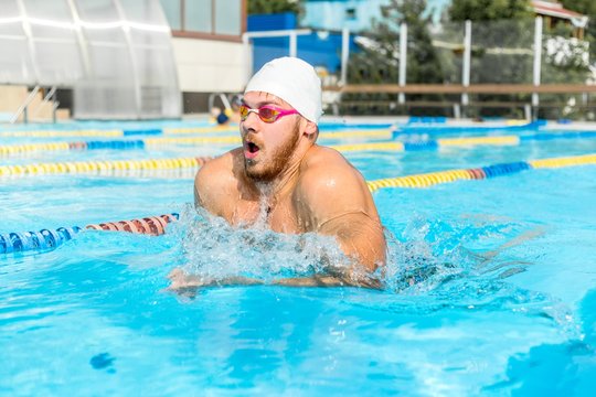 Man swims breaststroke in the pool