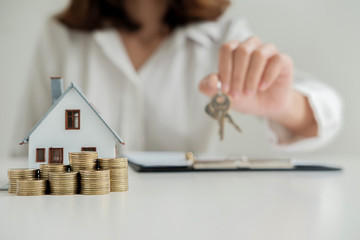 Real estate agent giving the keys to customer for deal contract to buy house, insurance or loan...